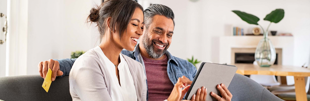 couple on couch looking at tablet